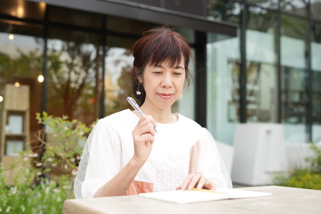 Singer-songwriter writing lyrics in a notebook at an outdoor café